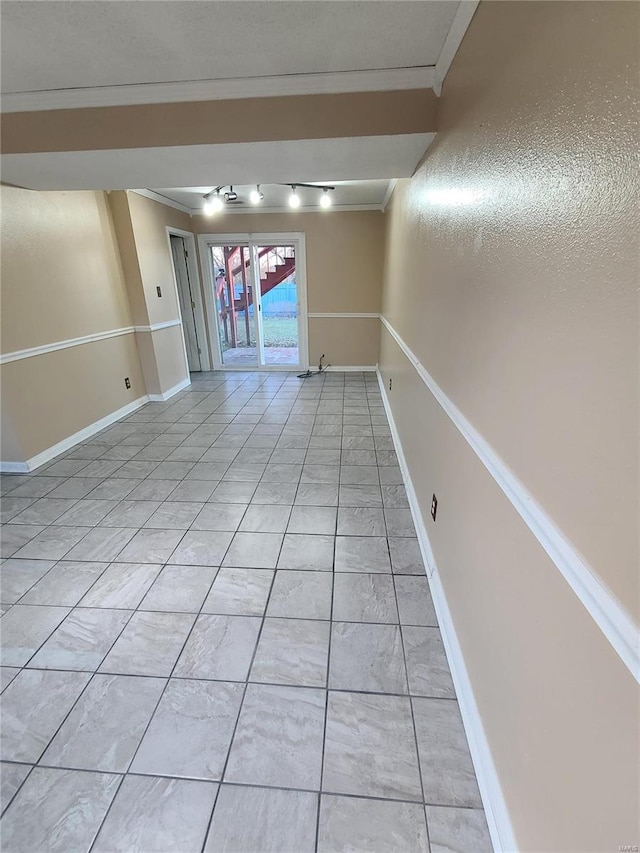 unfurnished room featuring ornamental molding and light tile patterned flooring