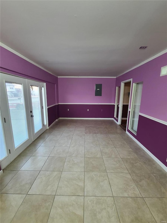 tiled spare room with ornamental molding, electric panel, and french doors