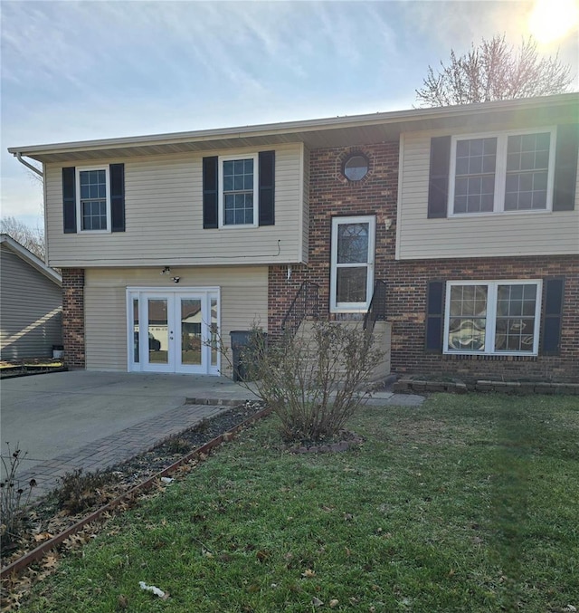 split foyer home with a yard, a patio area, and french doors