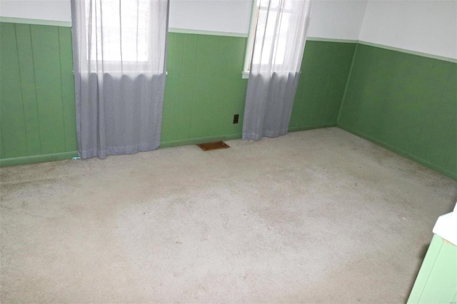 carpeted spare room featuring plenty of natural light