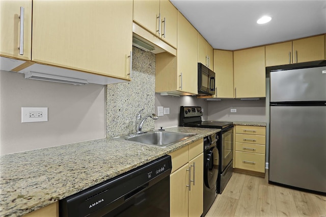 kitchen with tasteful backsplash, sink, black appliances, light brown cabinets, and light hardwood / wood-style flooring