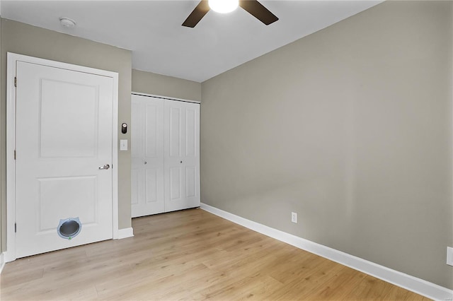 unfurnished bedroom with a closet, light hardwood / wood-style flooring, and ceiling fan