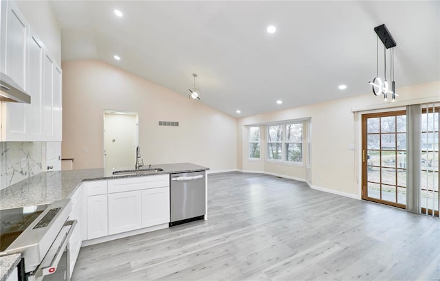 kitchen featuring white cabinets, appliances with stainless steel finishes, open floor plan, hanging light fixtures, and a sink