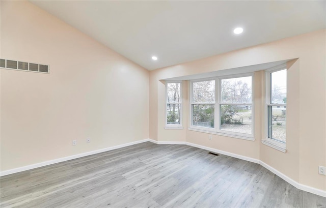 unfurnished room with light wood finished floors, recessed lighting, visible vents, and baseboards