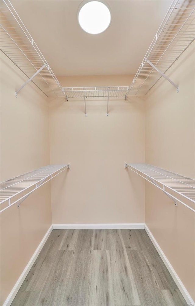 walk in closet with light wood-style flooring