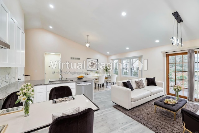 living room featuring recessed lighting, visible vents, vaulted ceiling, and light wood-style flooring