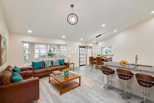 living area featuring light wood-type flooring, lofted ceiling, and recessed lighting