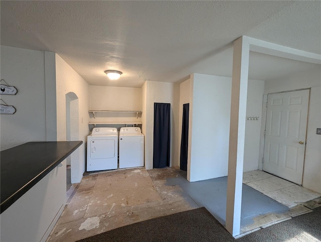 laundry area featuring separate washer and dryer and a textured ceiling