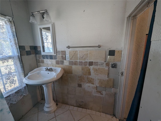 bathroom featuring tile patterned flooring and tile walls