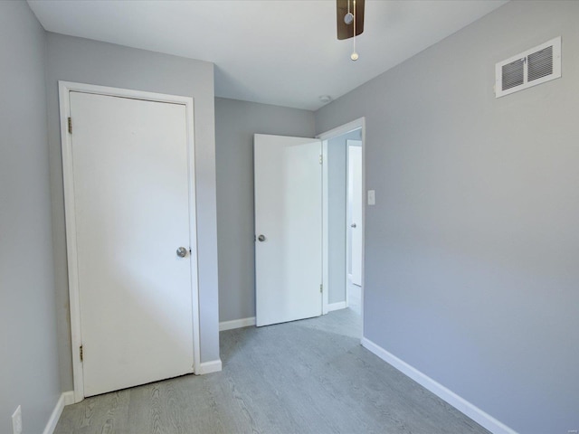 unfurnished bedroom with a closet, light hardwood / wood-style flooring, and ceiling fan