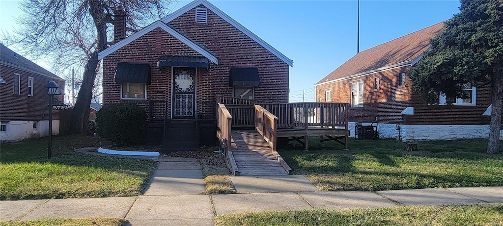 bungalow with a front yard and a deck