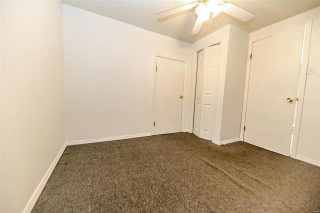 unfurnished bedroom featuring ceiling fan and dark carpet