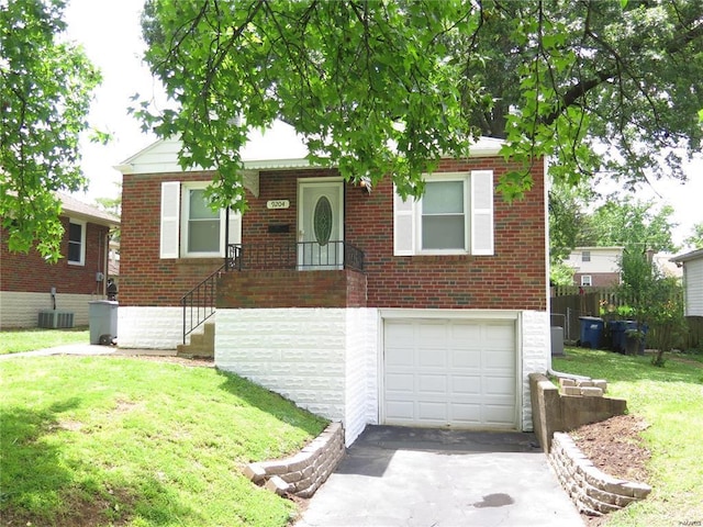 view of front of home with a front yard, a garage, and central AC unit