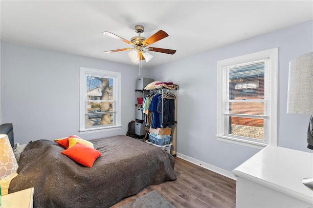 bedroom featuring multiple windows, ceiling fan, and wood-type flooring