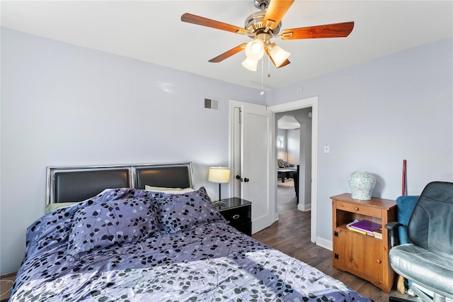 bedroom with dark hardwood / wood-style flooring and ceiling fan