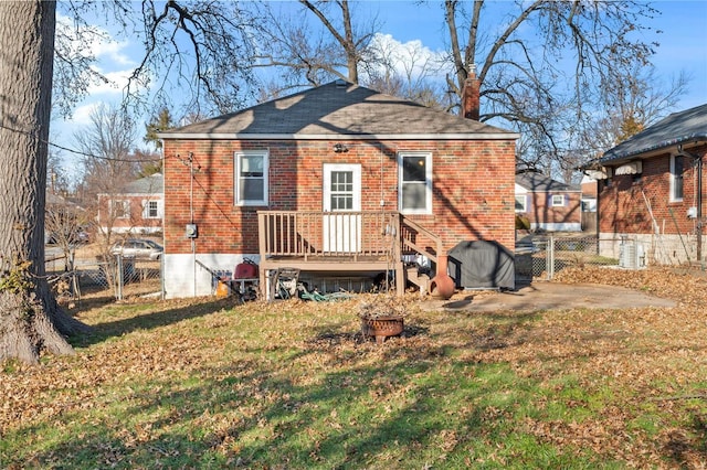 rear view of house featuring a lawn and a patio