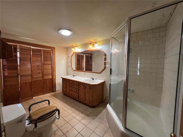 full bathroom with tile patterned floors, vanity, combined bath / shower with glass door, and toilet