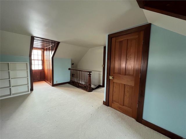 bonus room featuring light colored carpet and vaulted ceiling