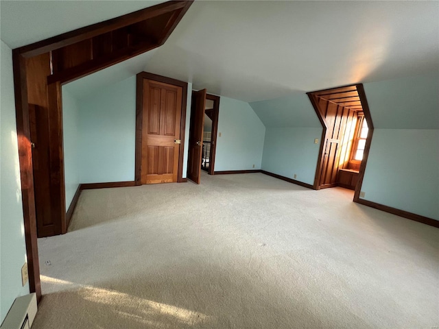 bonus room with light colored carpet and vaulted ceiling