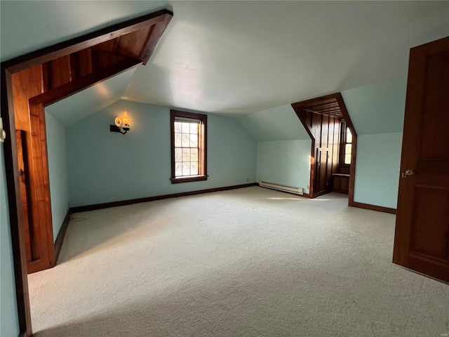 additional living space featuring light carpet, vaulted ceiling, and baseboard heating