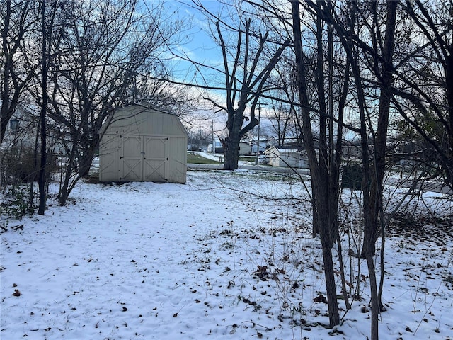 yard layered in snow featuring a storage unit