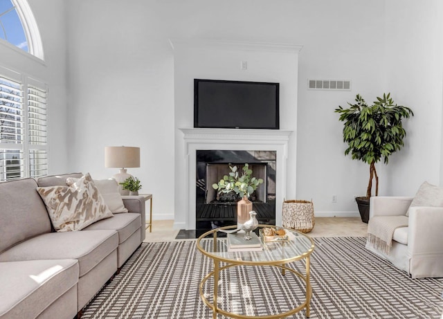 living room featuring a premium fireplace and crown molding