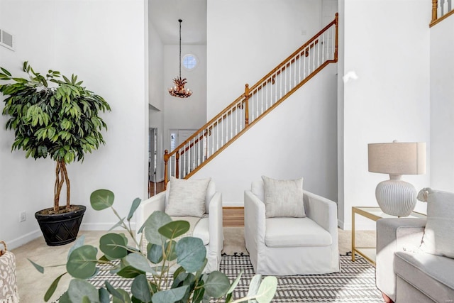 carpeted living room with a towering ceiling