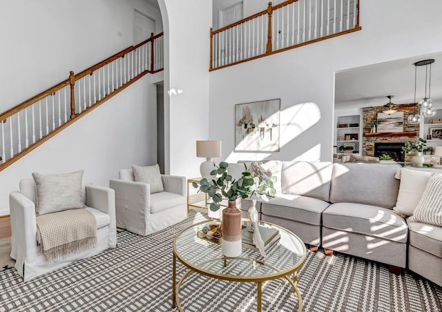 carpeted living room featuring built in shelves, a towering ceiling, and a fireplace