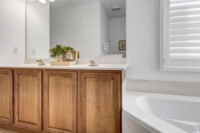 bathroom featuring vanity and a bath