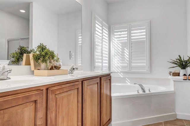 bathroom with a bathtub, vanity, and tile patterned flooring