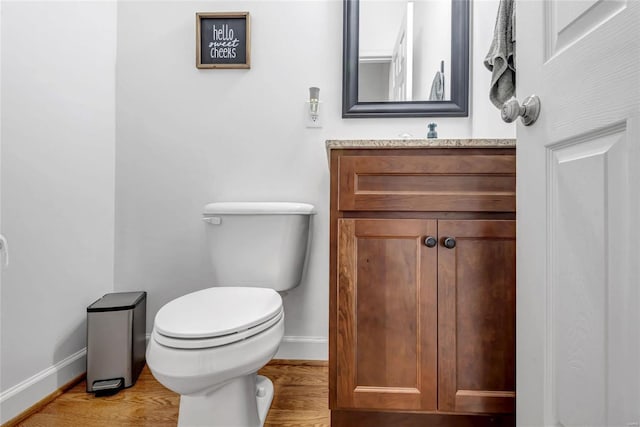 bathroom featuring toilet, hardwood / wood-style flooring, and vanity