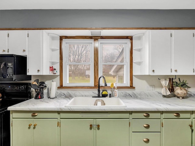 kitchen with backsplash, black / electric stove, sink, and white cabinets