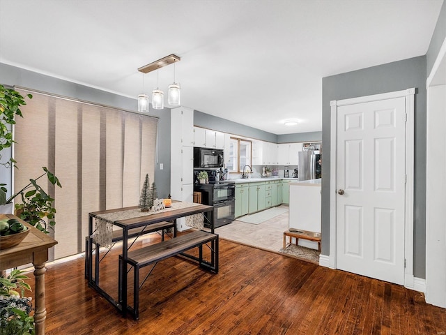 dining room featuring sink, wood-type flooring, and an inviting chandelier