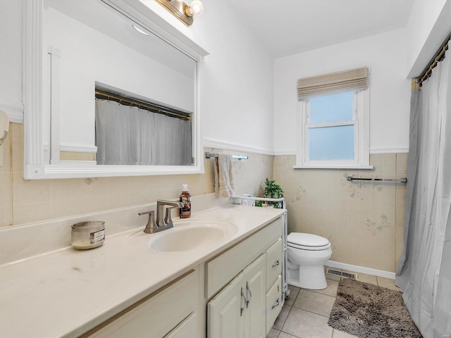 bathroom featuring tile patterned flooring, vanity, tile walls, and toilet