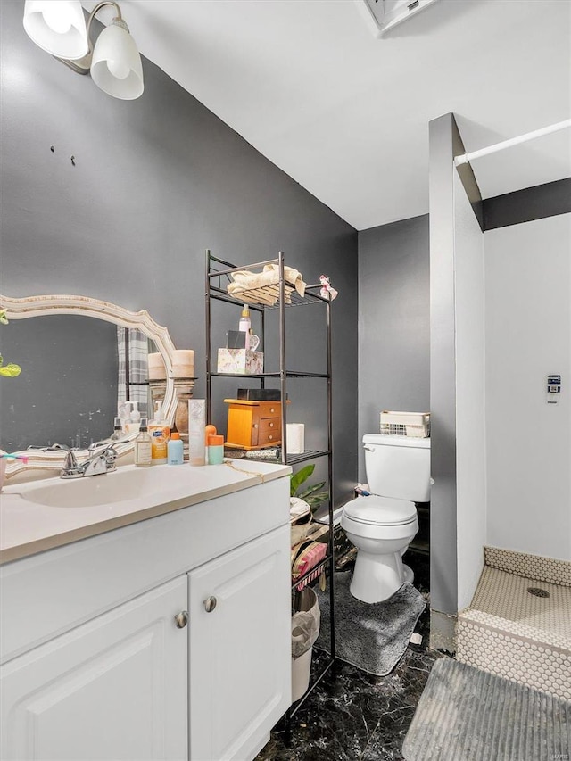 bathroom featuring vanity, toilet, and walk in shower