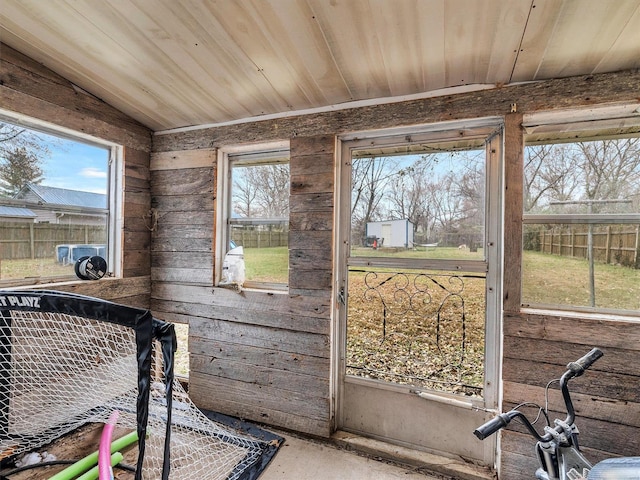 sunroom / solarium featuring a wealth of natural light, wood ceiling, and vaulted ceiling