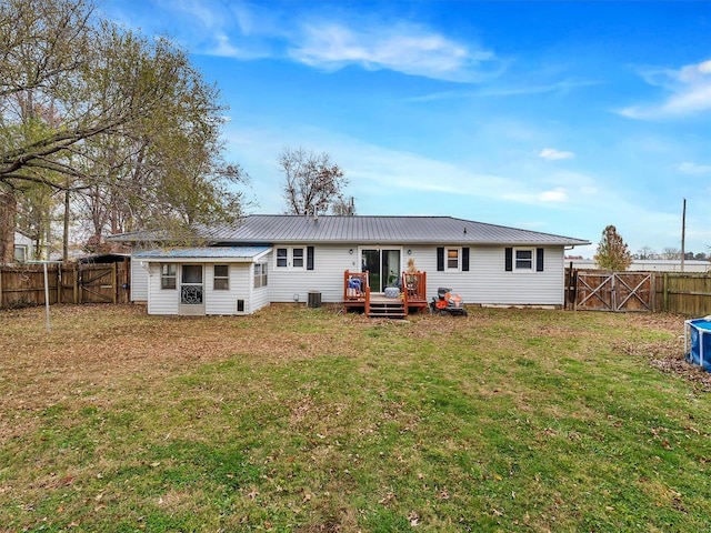 rear view of property with a wooden deck, a yard, and cooling unit