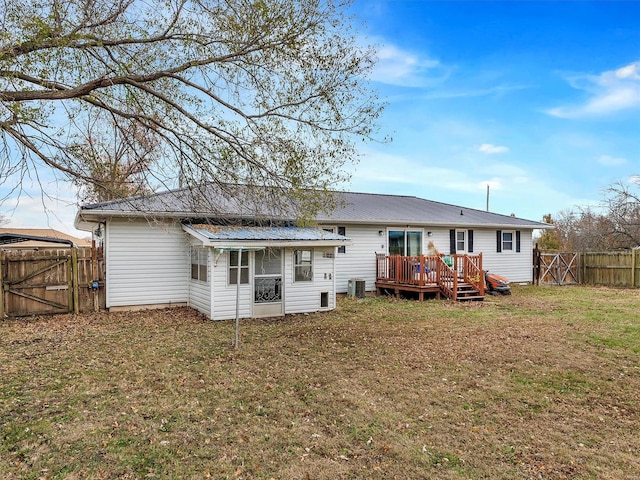 rear view of property featuring a lawn, cooling unit, and a wooden deck