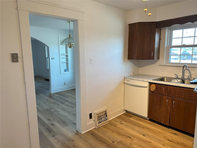 kitchen featuring dark brown cabinets, white dishwasher, sink, an inviting chandelier, and light hardwood / wood-style floors