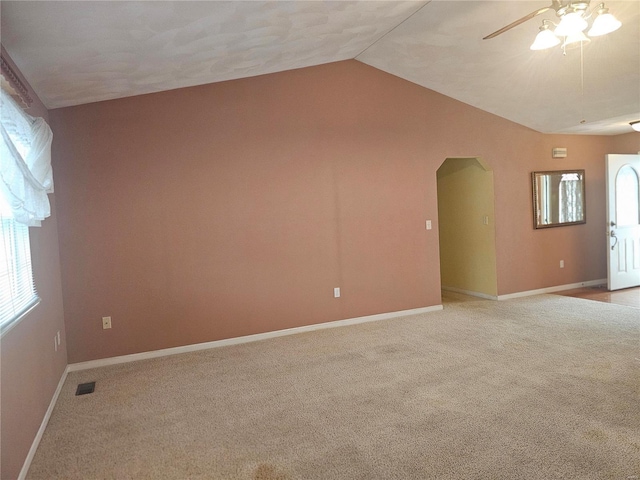 carpeted spare room featuring ceiling fan and vaulted ceiling