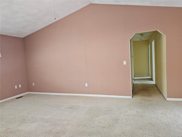 carpeted empty room featuring lofted ceiling