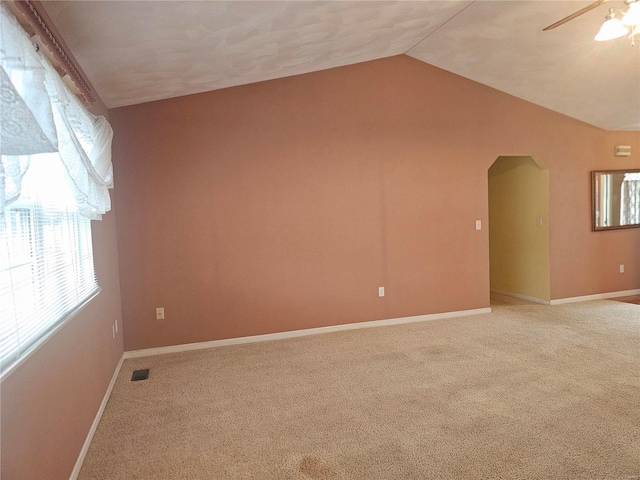 carpeted empty room with ceiling fan and lofted ceiling