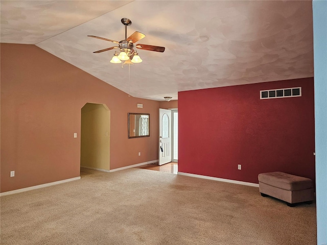 carpeted spare room featuring ceiling fan and lofted ceiling