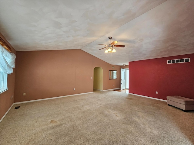 interior space featuring a wealth of natural light, carpet, and vaulted ceiling