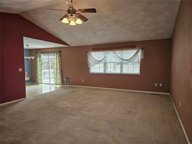 spare room with ceiling fan with notable chandelier, lofted ceiling, and carpet floors