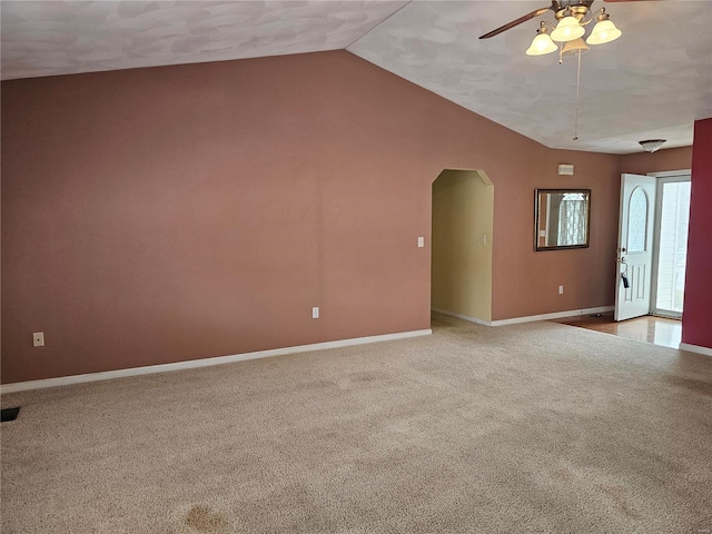 carpeted empty room featuring ceiling fan and vaulted ceiling