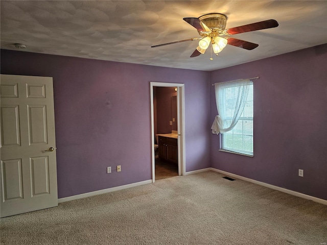 unfurnished bedroom with ensuite bathroom, ceiling fan, and light colored carpet