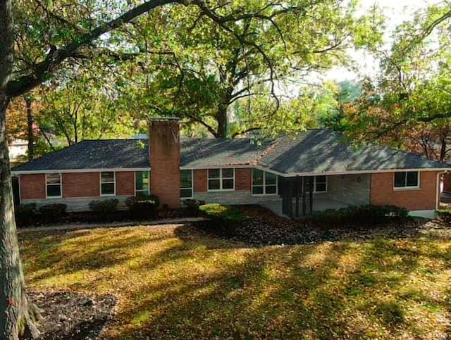 rear view of property featuring a lawn