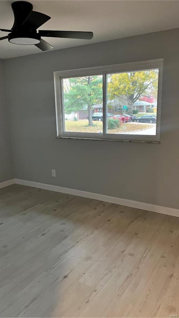 unfurnished room featuring plenty of natural light, ceiling fan, and light hardwood / wood-style flooring