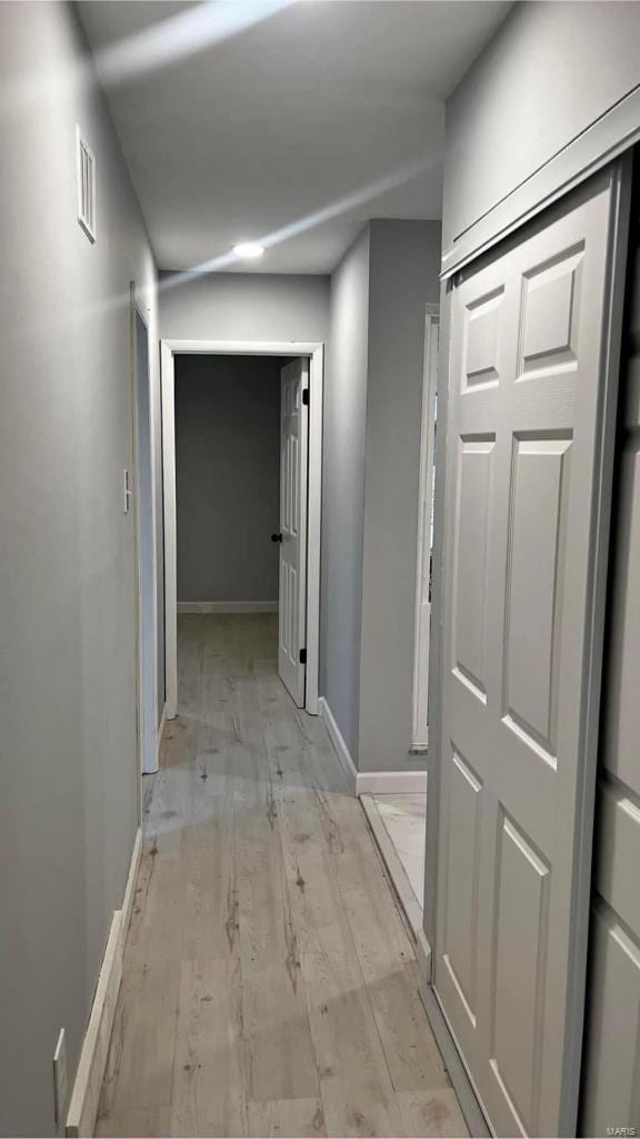 corridor with light hardwood / wood-style floors